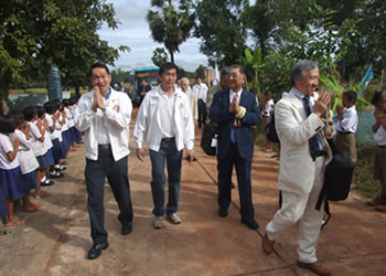 1校目式典会場のBaan Muad Air Schoolに到着しタイ式挨拶で学校へ向かう2510地区、ノンカイRCメンバー